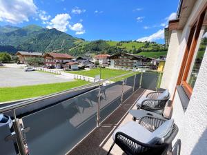 a balcony with chairs and a view of the mountains at Appartements by Hofer in Kaprun