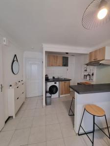 a large white kitchen with a counter and a dishwasher at Appartement coquet Le Boulou in Le Boulou