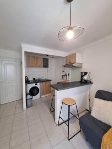 a kitchen and living room with a table and a couch at Appartement coquet Le Boulou in Le Boulou