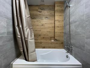 沃尔泽利Iris Hotels Resort的带淋浴和白色浴缸的浴室