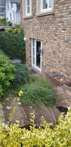 a brick house with a front door and grass at Souterrain - a72405 in Rheinbach