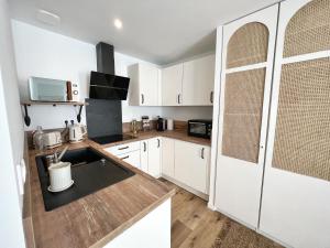 a kitchen with white cabinets and a counter top at Le Cocon - Coeur de ville in La Rochelle