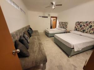 Habitación de hotel con 2 camas y sofá en Departamento planta baja playa centro monos bichis, en Mazatlán