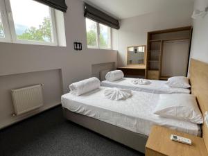 2 Betten in einem Zimmer mit 2 Fenstern in der Unterkunft Iris Hotels Resort in Worsel