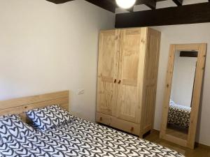 1 dormitorio con 1 cama y armario de madera en Monforte de la Sierra - Acogedora y cálida vivienda, 