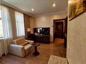 a living room with a couch and a television at Smith's Hotel in Baku