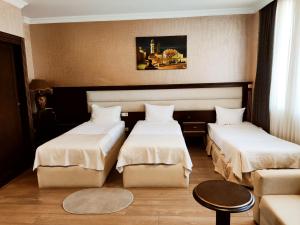 a hotel room with two beds and a couch at Smith's Boutique Hotel in Baku