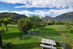 a picnic table in a field with mountains in the background at Casa Gerolamo - Happy Rentals in Esino Lario