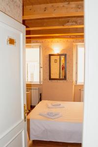 - une chambre avec un lit et une table blanche dans l'établissement Hotel capitelli, à Trieste