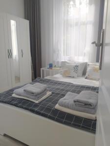 łazienka z 2 łóżkami i lustrem z ręcznikami w obiekcie Apartament FANABERIA Lądek Zdrój w mieście Lądek-Zdrój
