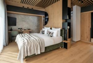 ein Schlafzimmer mit einem großen Bett und einem Schreibtisch in der Unterkunft NEUWIRT - Boutiquehotel & Wirtshaus in Bad Vigaun