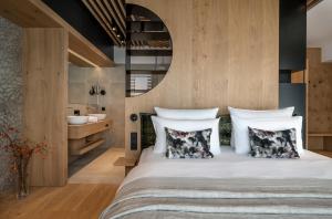 sypialnia z dużym łóżkiem z poduszkami w obiekcie NEUWIRT - Boutiquehotel & Wirtshaus w mieście Bad Vigaun