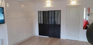 une chambre avec des armoires blanches et une porte noire dans l'établissement Appartement 2 ch 40 m2 au pied des pistes de ski, à Enchastrayes