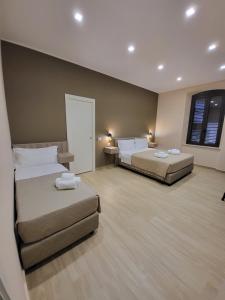 een hotelkamer met 2 bedden en een raam bij B&B La Cité Luxury Rooms in Reggio di Calabria