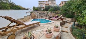 a patio with a swimming pool with chairs and potted plants at Apartment Nikola in Jelsa