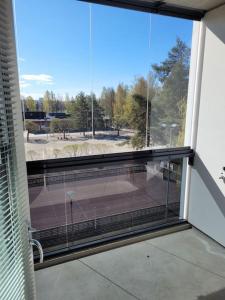 une grande fenêtre avec vue sur un court de tennis dans l'établissement Professori, à Joensuu