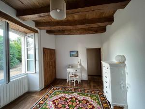 Zimmer mit einem Tisch und einem Teppich auf dem Boden in der Unterkunft Le Mas de Coursac in Quissac