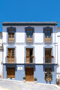 un edificio blu e bianco con finestre e balconi di Villa Moana a Iznájar