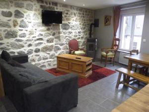 sala de estar con pared de piedra en Villa Boston, en La Bourboule