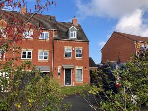 a large red brick house with a driveway at Spacious Townhouse with Parking in Telford