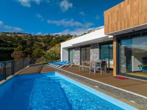 a villa with a swimming pool and a house at Casa Mozart II in Estreito da Calheta