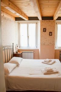 twee bedden in een kamer met twee ramen bij Hotel capitelli in Trieste