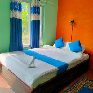 Hotel Tiger Tops Sauraha في سوراها: غرفة نوم بسرير كبير وبجدران زرقاء وأخضر
