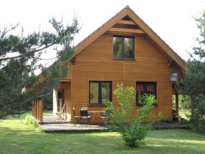 una pequeña casa de madera con porche en Za piecem en Guzowy Piec