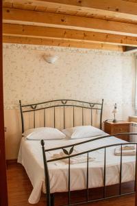 Ce lit se trouve dans une chambre dotée d'un plafond en bois. dans l'établissement Hotel capitelli, à Trieste