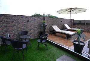 a patio with chairs and tables and an umbrella at The Relyn Suite in Shillong