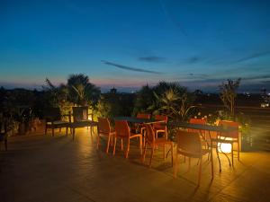 a group of tables and chairs on a patio at night at Nuova Opera Rooms in Verona