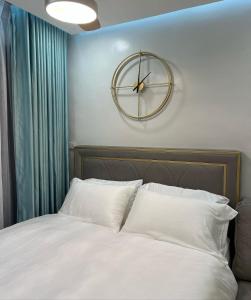 a bedroom with a bed with a clock on the wall at KILA Homes at Pine Suites Tagaytay in Tagaytay