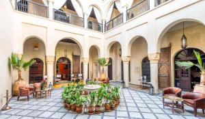 een binnenplaats met een tafel met planten in een gebouw bij Riad Boustane in Marrakesh