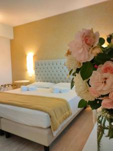 una camera da letto con un letto con fiori rosa in un vaso di Nuova Opera Rooms a Verona