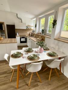 a kitchen with a white table and white chairs at Sunny Oak Estate in Mengeš