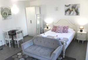 Un dormitorio con una cama, un sofá y una mesa. en Casa do Largo, en Lagoa
