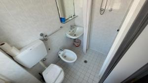 La salle de bains est pourvue de toilettes, d'un bidet et d'un lavabo. dans l'établissement Hotel Villa Dina, à Rimini