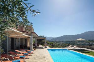 a villa with a swimming pool and mountains in the background at Villa Luni in episkopi-chania