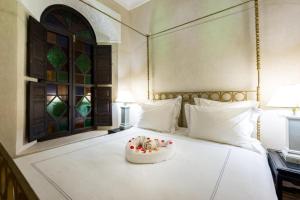 a bedroom with a bed with a bowl of fruit on it at Riad Boustane in Marrakech