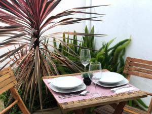 Una mesa de madera con platos y copas de vino encima. en Casa do Largo, en Lagoa 11 fotos más