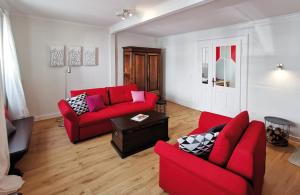 ein Wohnzimmer mit zwei roten Sofas und einem Tisch in der Unterkunft Dautzenberg Ferienapartments in Bad Neuenahr-Ahrweiler