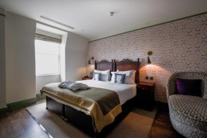 Pokój hotelowy z łóżkiem i krzesłem w obiekcie Morton Hotel w Londynie