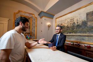 dos hombres están dando la mano en una mesa en Sapphire City Hotel, en Baku