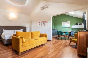 a living room with a yellow couch and a bedroom at easyhomes Duomo View in Milan