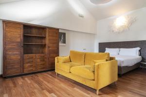 een slaapkamer met een bed en een gele stoel bij easyhomes Duomo View in Milaan