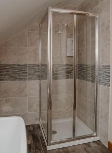 a shower with a glass door in a bathroom at Lovely new 1 bedroom loft apartment with on drive parking in Trowbridge