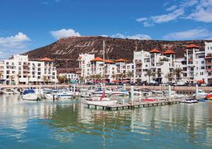 a group of boats docked in a marina with buildings at New Luxury Apartment Sea View in Agadir