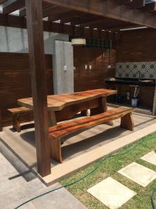 a wooden table and bench on a patio at Casa de Praia Tamandare in Tamandaré