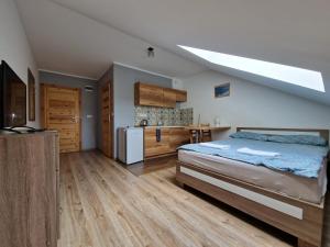 a bedroom with a large bed and a kitchen at Apartamenty Berg Karpacz in Karpacz