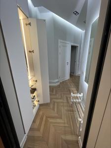 a hallway with white walls and wood flooring at Brand new one bedroom apartment with amazing view in Bishkek